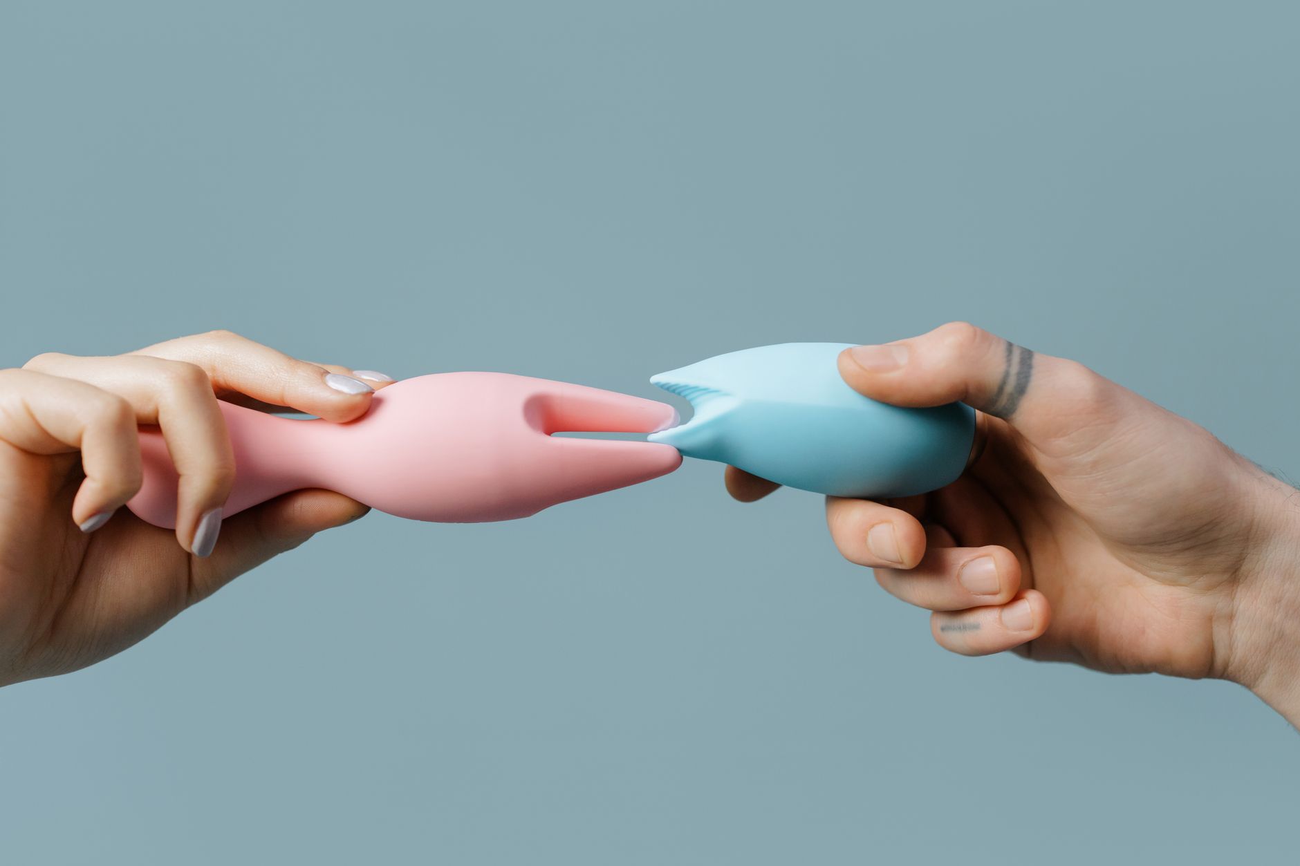 Woman holding silicone vibrators in contemplative moment, exploring sensation
